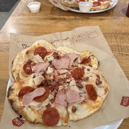 a person grabbing a slice of pizza