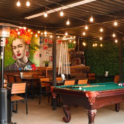 Photo showcasing the inside of the restaurant, including mural, pool table, and seating.