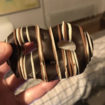 Varsano's Chocolate - a hand holding a chocolate donut - Chocolatiers & Shops Near Me - New York, New York
