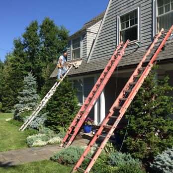 Elite Company - Exterior window repair and paint job underway with Elite Co owner, Wenes Negreli, on the ladder. - Windows Installation Near Me - Waltham, Massachusetts