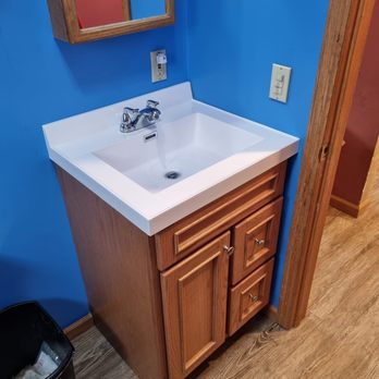 Structural Strategies - a bathroom with a sink and a trash can - Flooring Near Me Structural Strategies - a bathroom with a sink and a trash can - Flooring Near Me