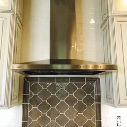 Studio 61 - Arabesque inlay above the stovetop included in a cream colored wrap around backsplash