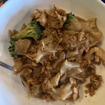 Kai Yang - Pad see yew - A bowl of Pad See Yew featuring wide rice noodles, broccoli, and slices of meat, served in a white bowl. - Thai Near Me - Montclair, New Jersey