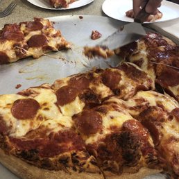 Large pepperoni pizza being shared inside Lena's.