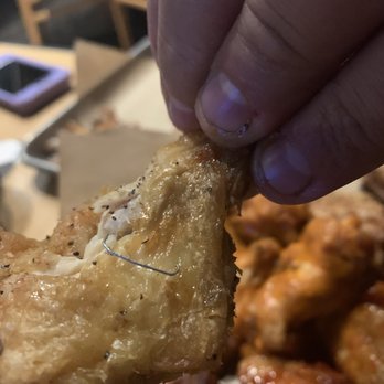 Buffalo Wild Wings - a hand holding a piece of fried buffalo wings - Sports Bars Near Me - New Philadelphia, Ohio Buffalo Wild Wings - a hand holding a piece of fried buffalo wings - Sports Bars Near Me - New Philadelphia, Ohio