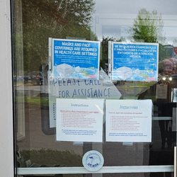 Newberg Urgent Care - Out of date signs and handwritten "please ask for assistance" in the background. Their idea of assistance is a joke. Picture taken 5-30-24