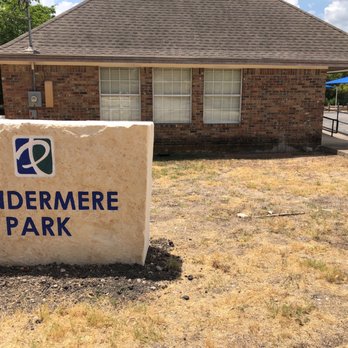 Windemere Park - A large stone sign with the text 'Windermere Park' is positioned in front of a brick building with three windows. - Parks Near Me - Pflugerville, Texas
