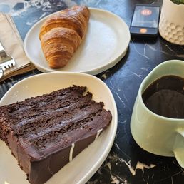 Decadent chocolate cake slice, butter croissant, and drip  coffee