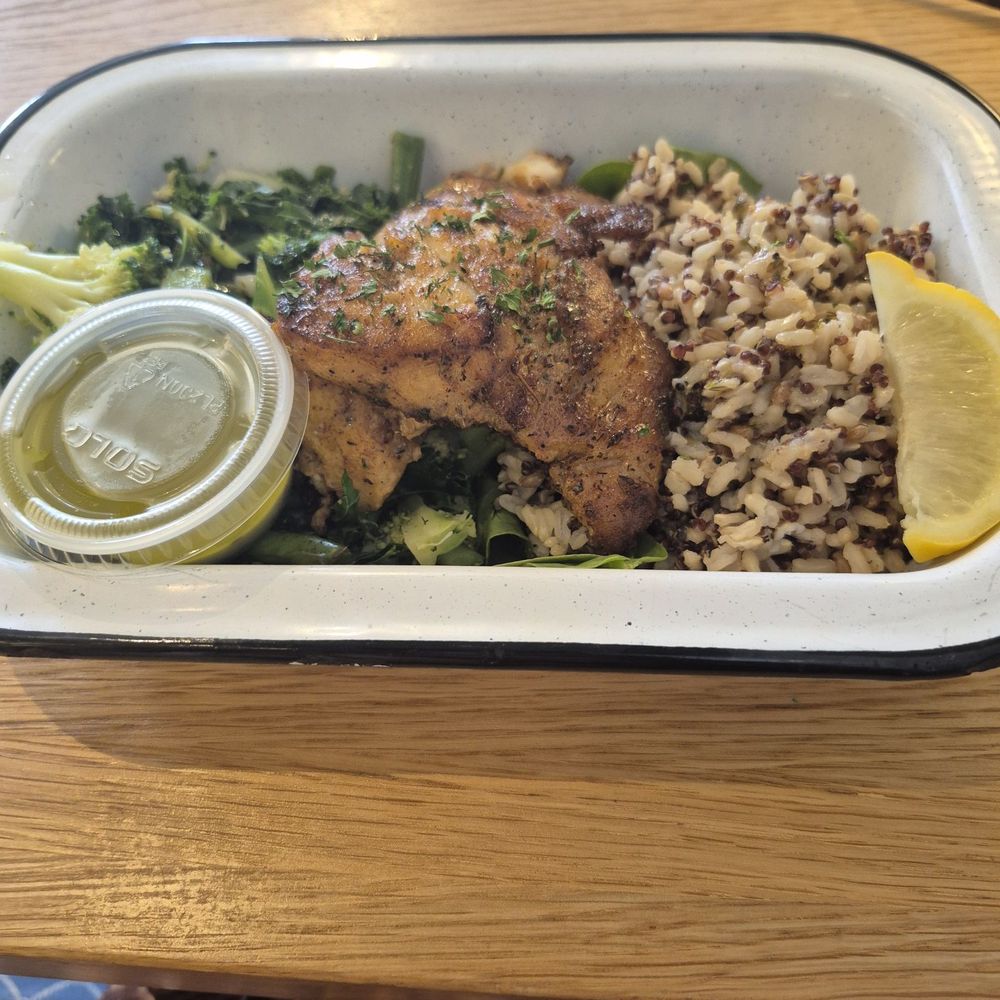 Blackened hake, an African fish, with greens and grains. Good and fresh! Garlic/herb sauce on the side was very tasty, but extra.