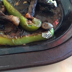 Fajita plate served with peppers that still had the stickers on them.