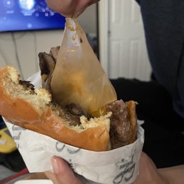 a person holding a sandwich in their hand a person holding a sandwich in their hand