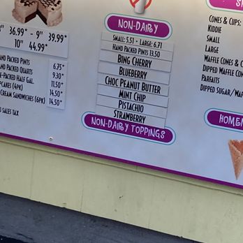 The Inside Scoop - Non-dairy flavors - A menu board from an ice cream shop features non-dairy ice cream flavors including Bing Cherry, Blueberry, Choc Peanut Butter, Mint Chip, Pistachio, and Strawberry, with prices for small and large sizes. It also lists non-dairy toppings, and the board is decorated with colorful labels and a partial image of a cake. The menu is displayed on a yellow background with purple accents. - Ice Cream & Frozen Yogurt Near Me - North Kingstown, Rhode Island