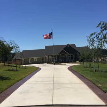 Final Finish Construction - a driveway leading to a building with an american flag on top - Flooring Near Me