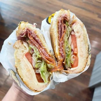 Which Wich - a person holding a sandwich in their hand - Sandwiches Near Me - Orland Park, Illinois