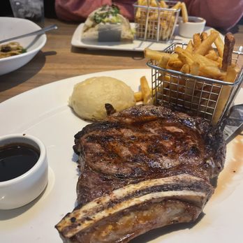 Yard House - 20oz Bone-in Ribeye w/ mashed potatoes and fries - Bars Near Me - Mcallen, Texas Yard House - 20oz Bone-in Ribeye w/ mashed potatoes and fries - Bars Near Me - Mcallen, Texas