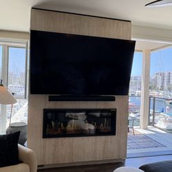 Custom faux wall build out for Slimline electric fireplace with Travertine style wall. This is a new stone laminate that we also installed.