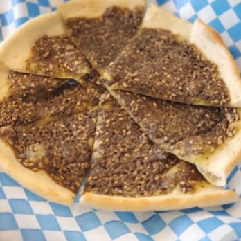 Haritna Streetsville - a cheese pizza on a blue and white checkered napkin - Desserts Near Me - Mississauga, Ontario