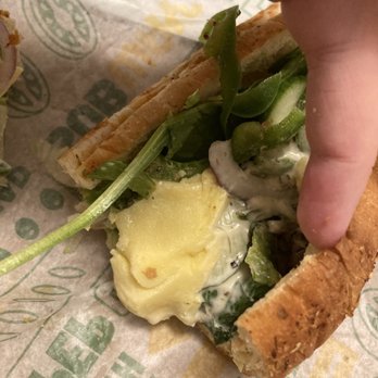 Subway - a hand holding a half eaten sandwich - Fast Food Near Me - New Minas, Nova Scotia
