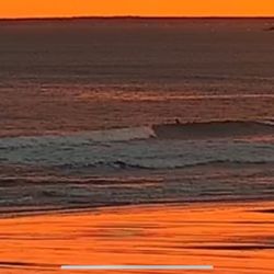 Higgins Public Beach - Surfers surfing waves at Higgins Beach at sunset