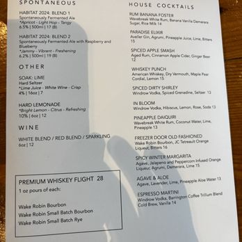 Trillium - Canton - Menu - The menu from Trillium Brewing includes sections for spontaneous beers, other beverages, wines, and whiskey flights. It lists specific beer blends, their alcohol content, volume, and descriptions. The house cocktails section features drinks like Rum Banana Foster, Paradise Elixir, and Whiskey Punch, with ingredients and prices. The whiskey flight offers four different 1 oz pours of various whiskey types. The menu also provides a guest WiFi password and social media icons. - Breweries Near Me - Canton, Massachusetts