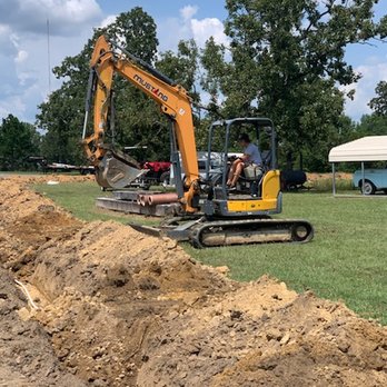 New Oak Construction - a man driving a small excavator - Excavation Services Near Me New Oak Construction - a man driving a small excavator - Excavation Services Near Me