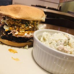 BBQ pork burger which includes a hamburger patty , bbq pulled pork, mustard bbq sauce and mayonnaise. Also shown potato salad BBQ pork burger which includes a hamburger patty , bbq pulled pork, mustard bbq sauce and mayonnaise. Also shown potato salad