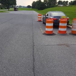 A Safeway Driving School - Use the crack beside the barrels to line your car up 3 feet away at the Brownstown DMV