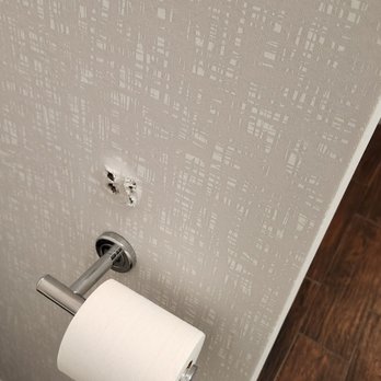 Hampton Inn Bellevue - holes in wall with dust on floor and nearby toilet - Hotels Near Me - Bellevue, Nebraska