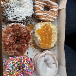 Cinnamon bun, Peach Pie, Vanilla Glazed, The Boardwalk, Bacon Maple, and Strawberry with rainbow sprinkles Cinnamon bun, Peach Pie, Vanilla Glazed, The Boardwalk, Bacon Maple, and Strawberry with rainbow sprinkles