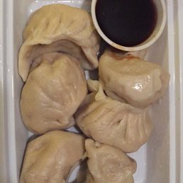 a plate of dumplings and dipping sauce
