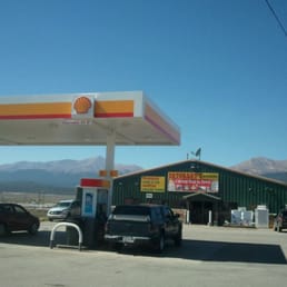 a gas station with cars parked in front of it a gas station with cars parked in front of it