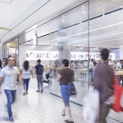 Queens Center - Shoppers walk past the busy Apple Store inside Queens Center.