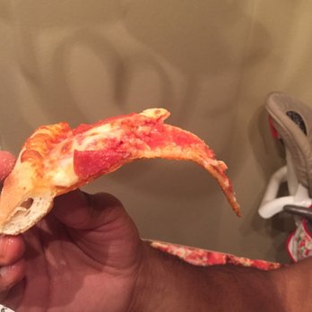 Marco's Pizza - a hand holding a slice of pizza - Pizza Near Me - San Antonio, Texas