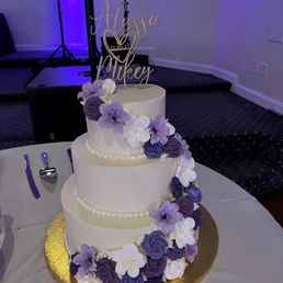 a wedding cake with purple and white flowers