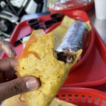 Taco Libre - a person holding a piece of food - Mexican Near Me - Pasadena, California Taco Libre - a person holding a piece of food - Mexican Near Me - Pasadena, California