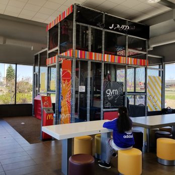 McDonald's - a woman sitting at a table in front of a vending machine - Fast Food Near Me - Maplewood, Minnesota McDonald's - a woman sitting at a table in front of a vending machine - Fast Food Near Me - Maplewood, Minnesota