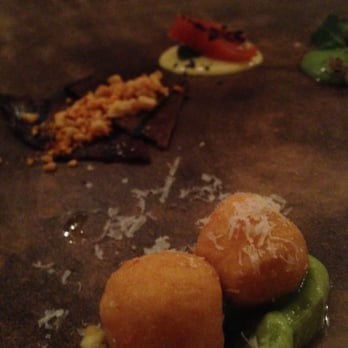 The Progress - Appetizers. Delicious gnocchi in the foreground with nut-covered jerky and salmon with sauce in the background - New American Near Me - San Francisco, California