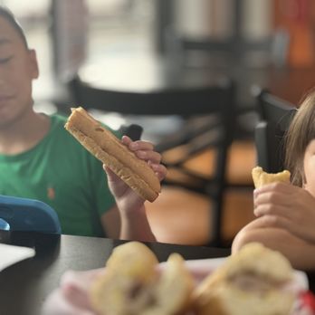 Le's Baguette - Kids enjoying the delicious taste of pate & butter on skinny french bread. - Sandwiches Near Me - Pinellas Park, Florida