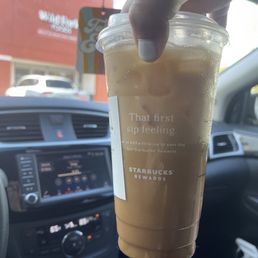 a hand holding a cup of iced coffee a hand holding a cup of iced coffee