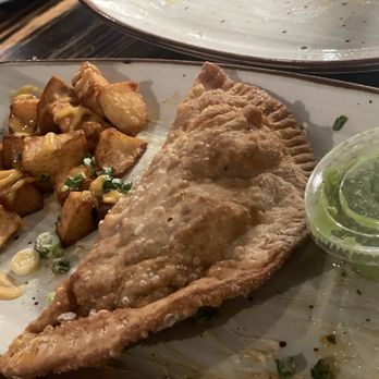 Pisco Latin Kitchen - Papas Bravas and Chicken Empanada with a delicious spicy sauce. - Latin American Near Me - Sandy Springs, Georgia Pisco Latin Kitchen - Papas Bravas and Chicken Empanada with a delicious spicy sauce. - Latin American Near Me - Sandy Springs, Georgia