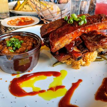 Creola Southern Steakhouse - Dry rubbed spare ribs...coated with tasty sauce and served with baked beans, risotto and green beans - Southern Near Me - Ithaca, New York