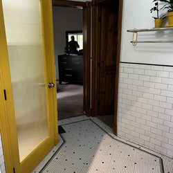 Alpha Cabinetry - Subway tiled wainscoting, detailed bordered penny tile floor, painted closet door