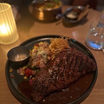 Earls Kitchen + Bar - a steak on a black plate - Canadian (New) Near Me - North York, Ontario