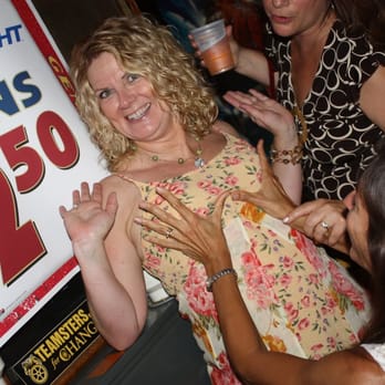 Marshall's Bar - a woman in a floral dress with her hands in the air - Bars Near Me - Detroit, Michigan
