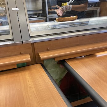 Subway - a man behind a window with a sandwich in his hand - Sandwiches Near Me - West Orange, Texas