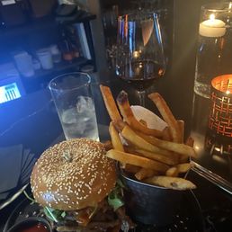 Burger, fries and glass of wine at the bar. Burger, fries and glass of wine at the bar.