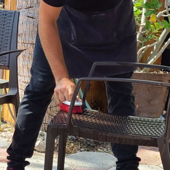 Kin Ha - One of the staff sanitizing the tables and chairs after every use - Mexican Near Me - Isla Mujeres, ROO Kin Ha - One of the staff sanitizing the tables and chairs after every use - Mexican Near Me - Isla Mujeres, ROO