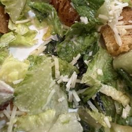 Old lettuce on top of very dirty tables that are not cleaned, full of old food and filthy carpets