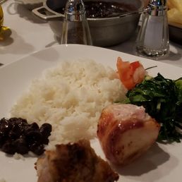 Bacon-wrapped chicken and pork with arroz, black beans, homemade chips, yucca fries and plantains, pico, greens Bacon-wrapped chicken and pork with arroz, black beans, homemade chips, yucca fries and plantains, pico, greens
