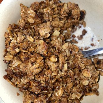 Java Joe's - a bowl of granola and milk - A bowl containing granola with oats, nuts, and dried fruit, with some milk at the bottom, served in a beige bowl. - Coffee & Tea Near Me - Albuquerque, New Mexico